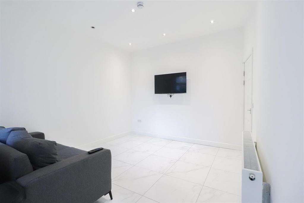 Bright, modern living room with white walls, gl...