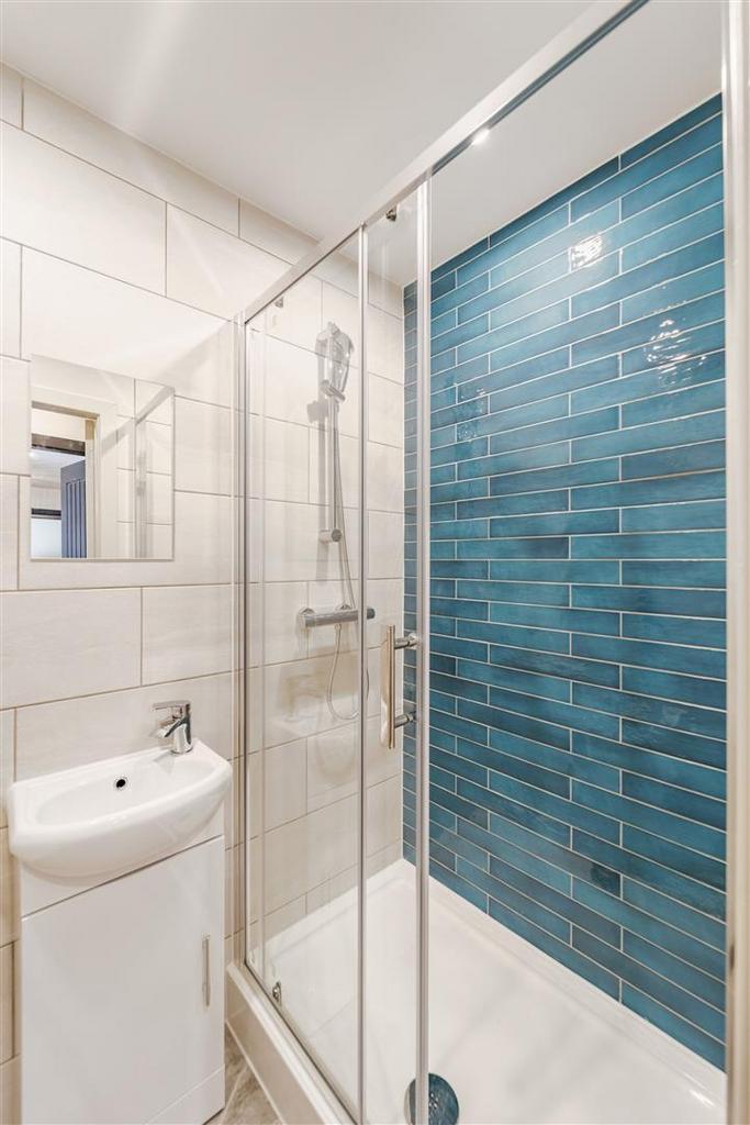 Modern bathroom with stylish blue-tiled shower...