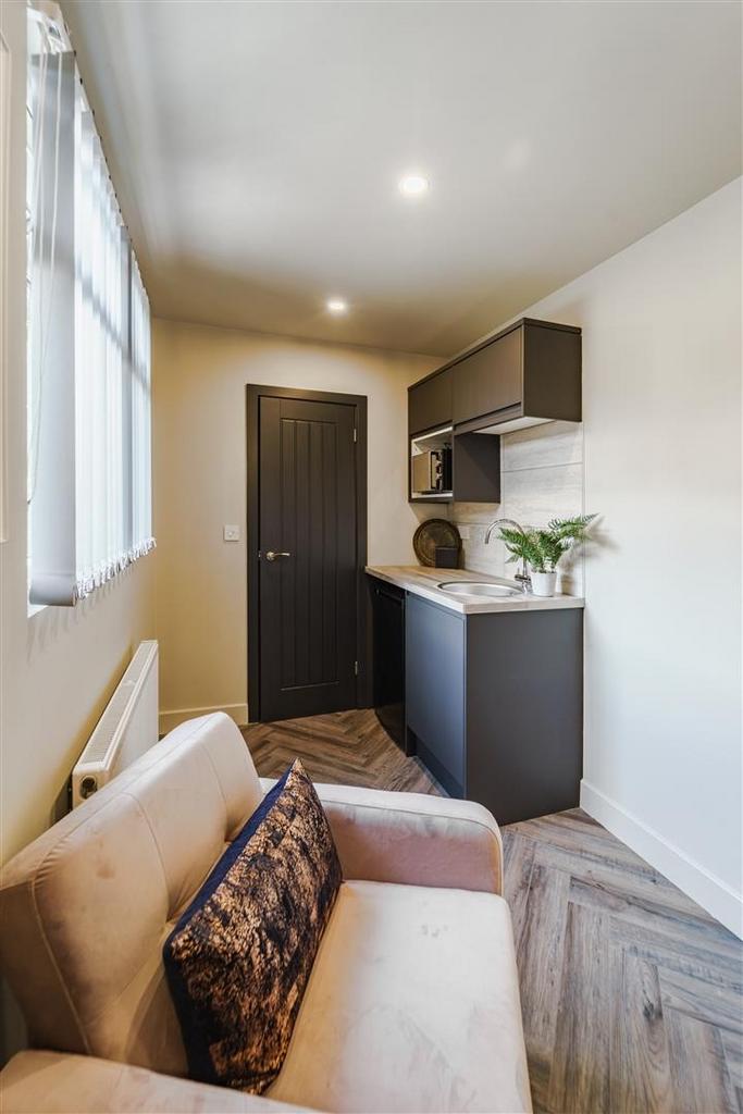 Compact kitchenette with seating and natural li...