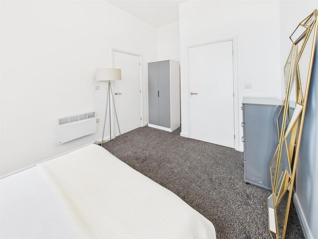 Bright, simply furnished bedroom with neutral d...