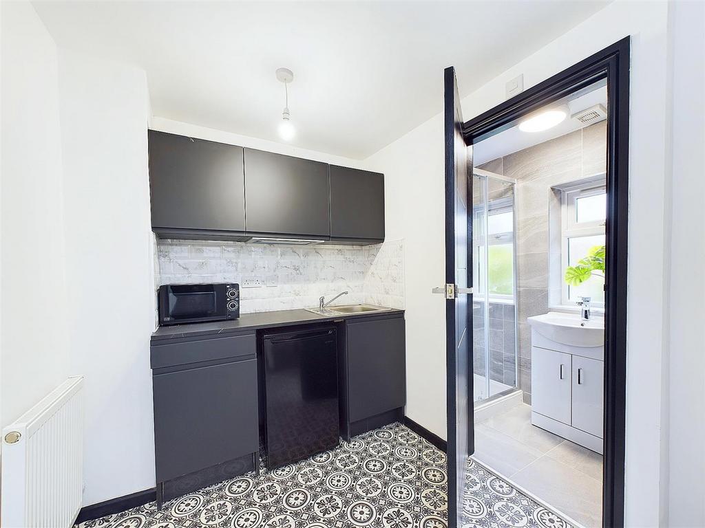Modern compact kitchen with patterned floor...