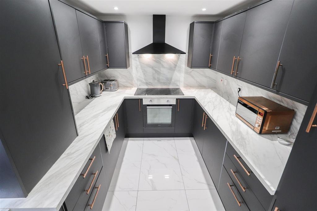 Modern U-shaped kitchen with marble surfaces...
