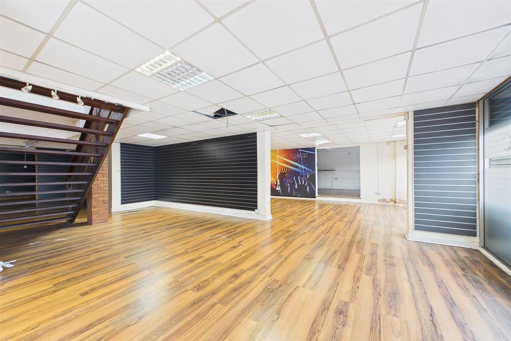 Spacious, modern communal lounge with wood-effe...
