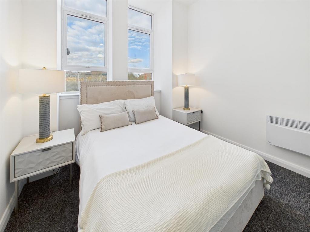 Bright, neatly styled bedroom with neutral deco...