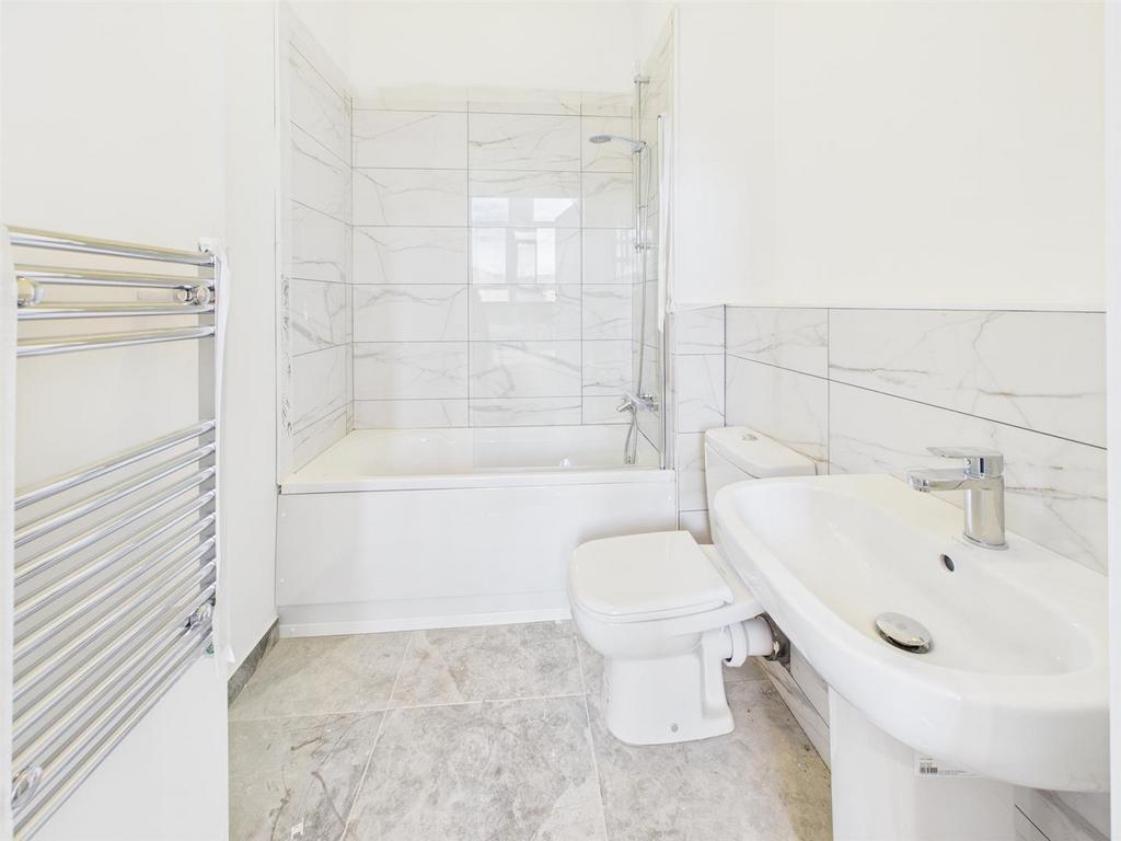 Bright modern bathroom with bath and heated rai...