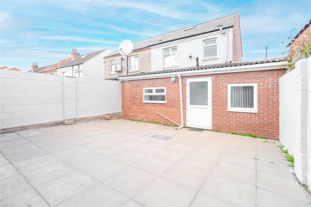 Spacious paved rear courtyard with low-maintena...