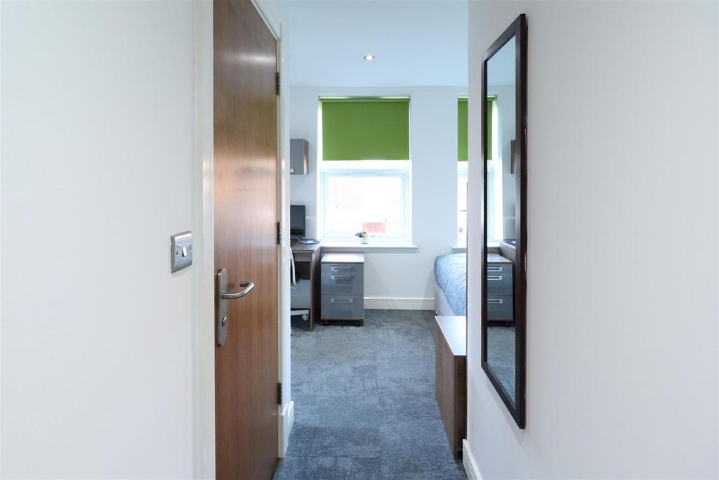 Bright, tidy bedroom with desk and window...