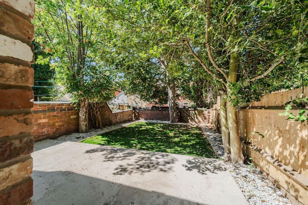 Private sunny garden with lawn and patio...