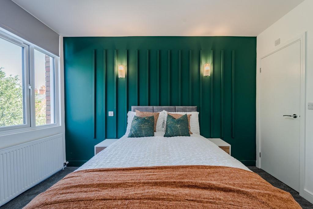 Stylish bedroom with bold feature wall and cosy...
