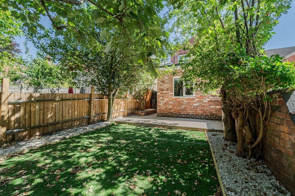 Private sunny garden with lawn and patio...
