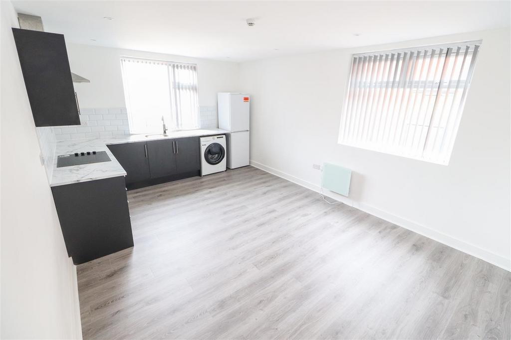 Bright open-plan living area with kitchenette...