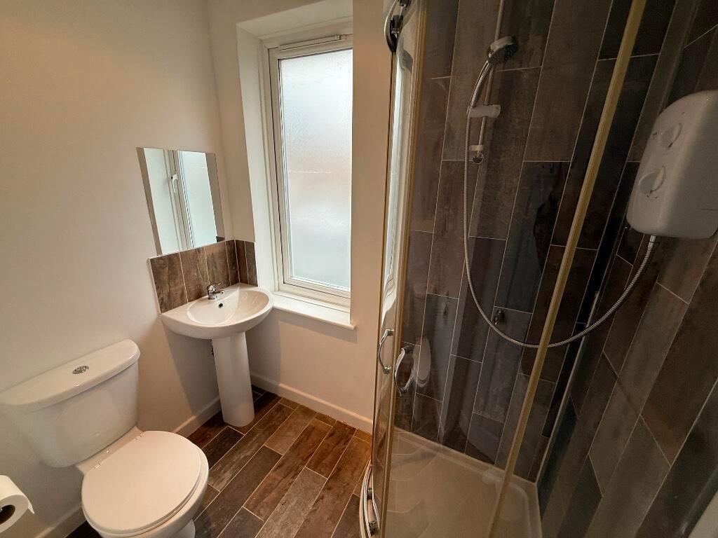 Modern tiled bathroom with a corner shower encl...