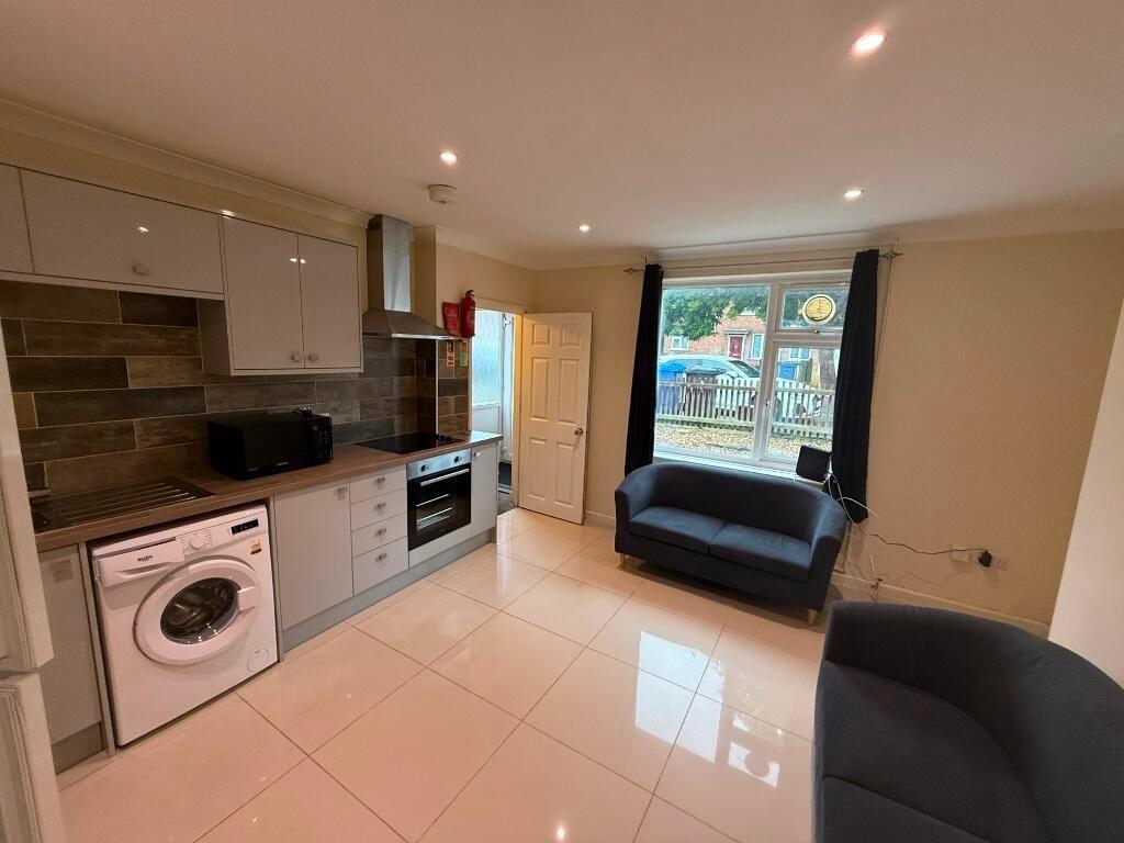 Bright open-plan lounge with a modern fitted ki...