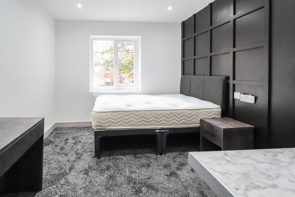 Bright, modern double bedroom with a feature bl...