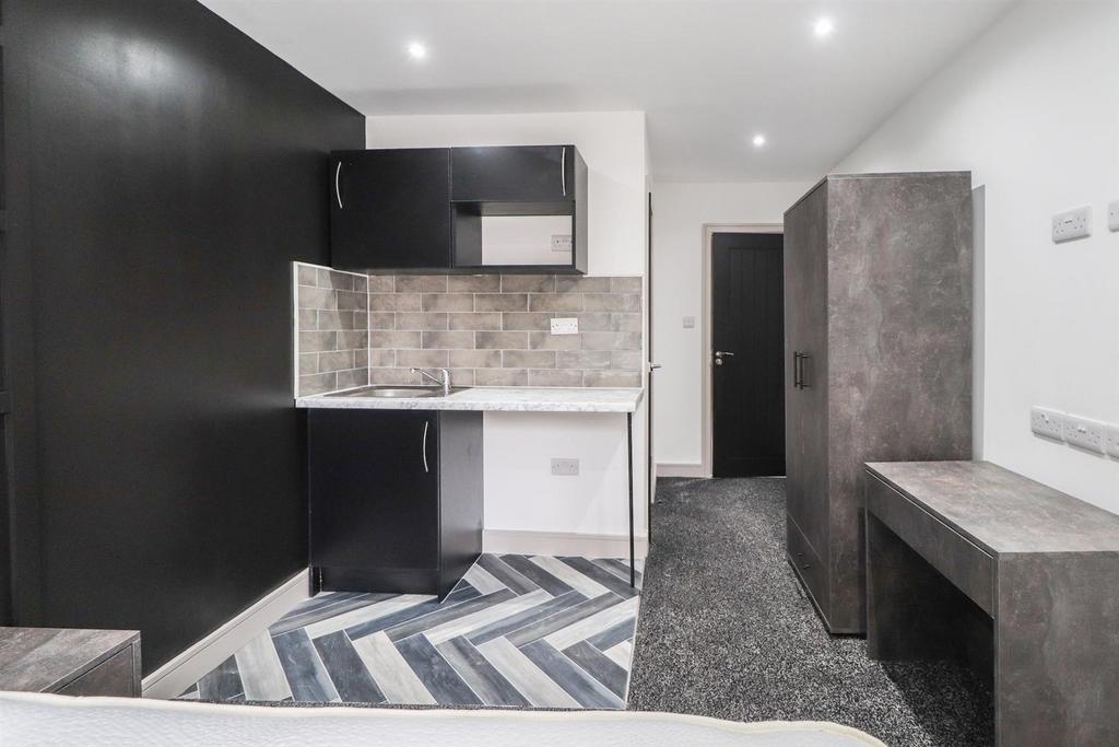 Modern studio with a compact fitted kitchenette...