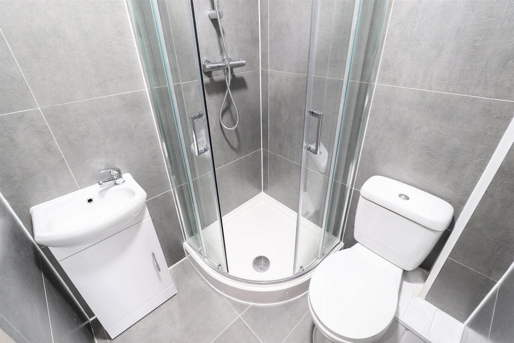 Bright, modern bathroom with tiled walls and fl...
