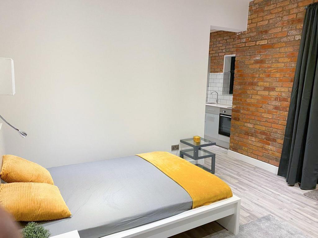 Neat bedroom with bright accent linens and expo...