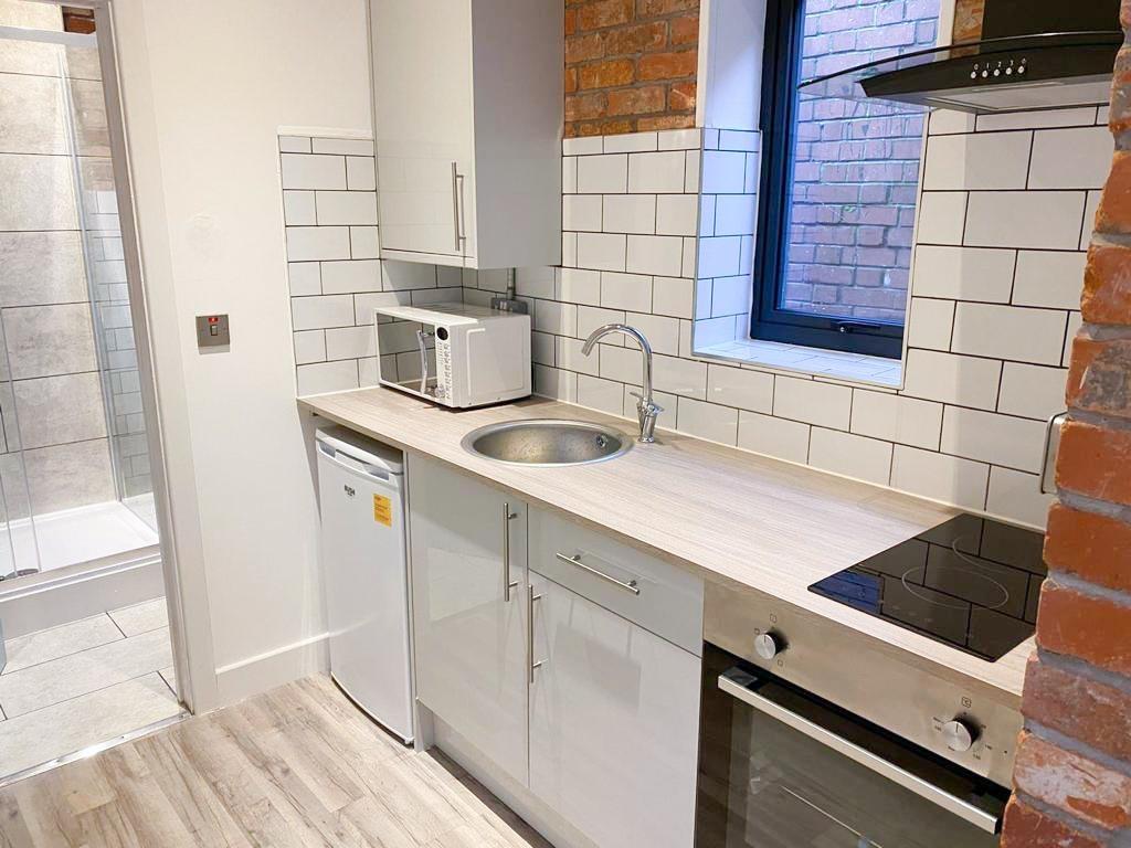 Compact modern kitchen with tiled splashback...