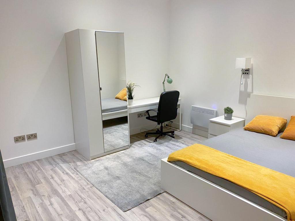 Bright, modern bedroom with study area and stor...