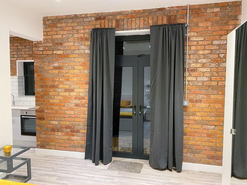 Stylish living area with exposed brick and glas...