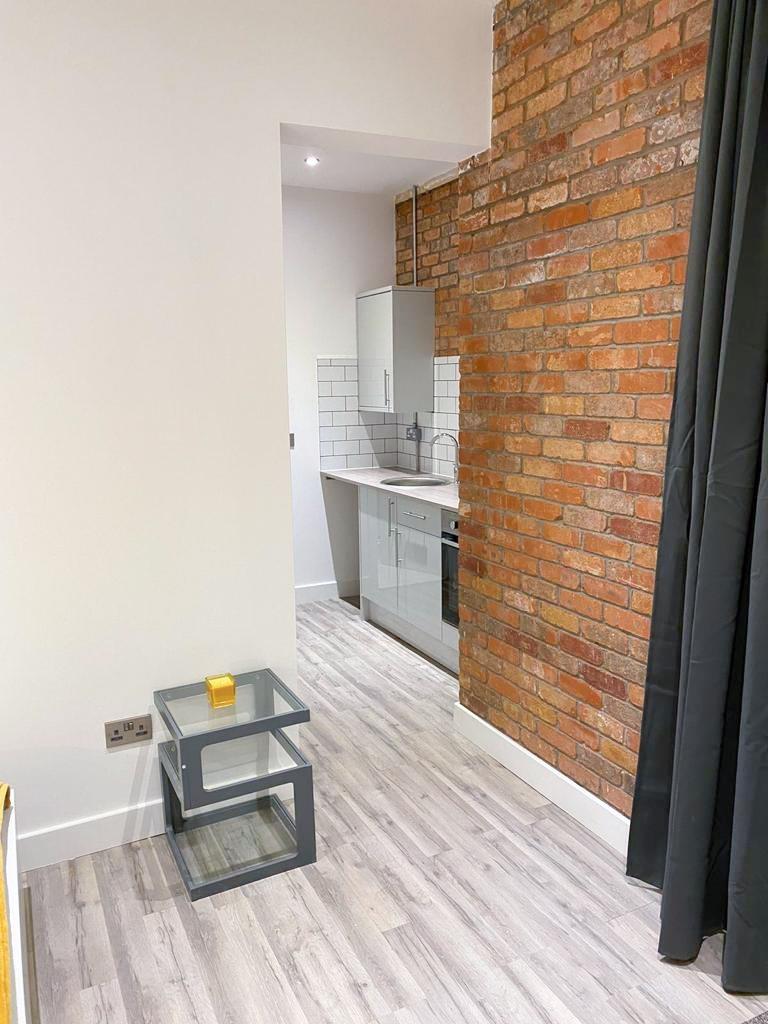 Modern kitchenette with exposed brick and wood‑...