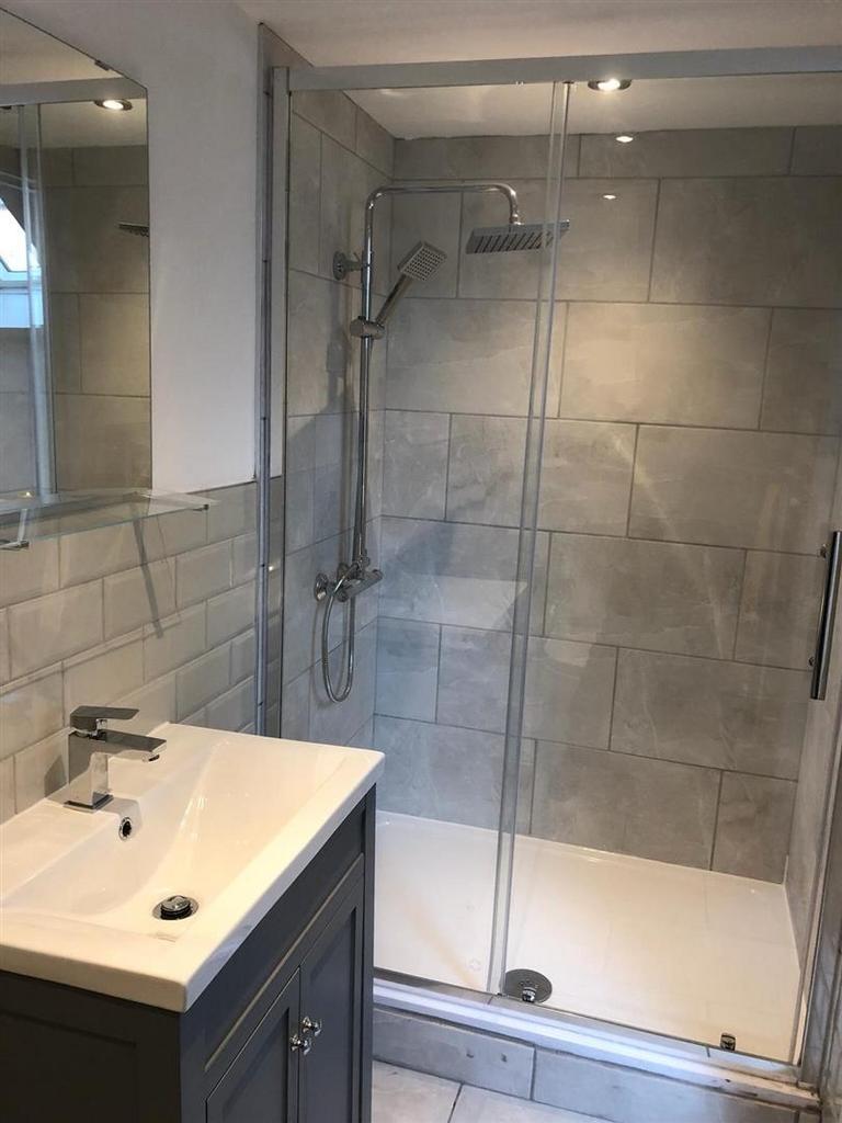 Modern tiled bathroom with glass shower...