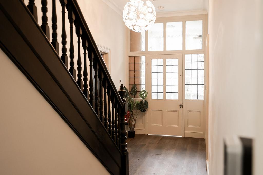 Bright hallway with classic staircase and tiled...