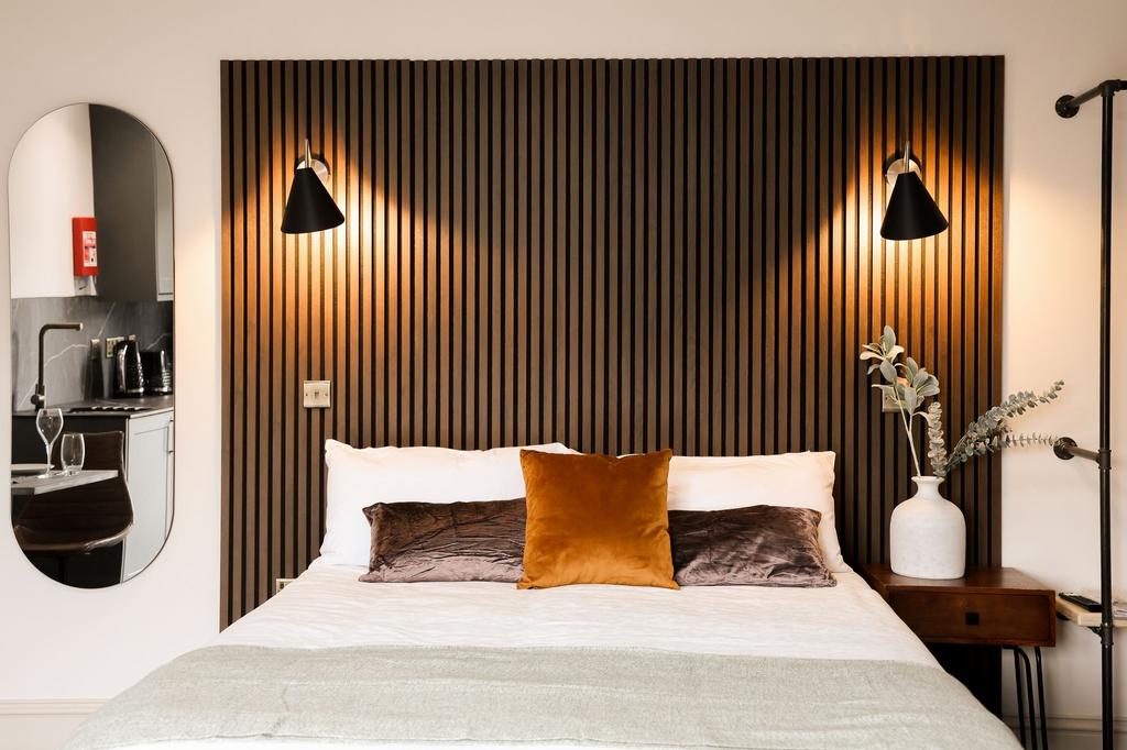 Stylish bedroom with wooden feature wall and wa...