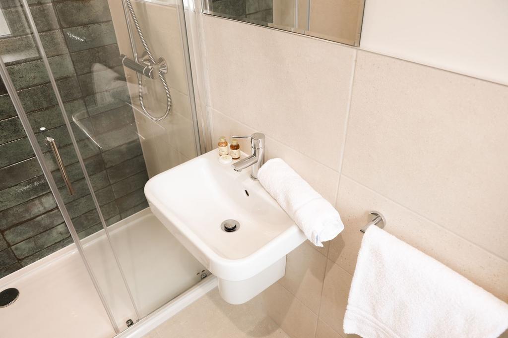 Modern ensuite with glass shower and clean sink...