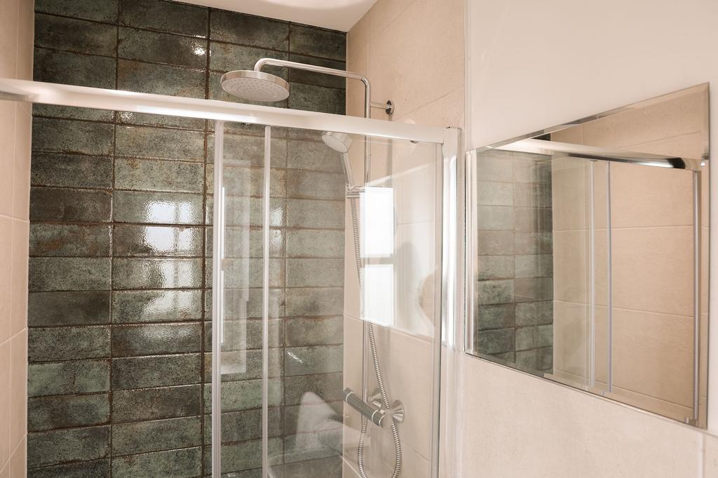 Modern shower with stylish tiled feature wall...