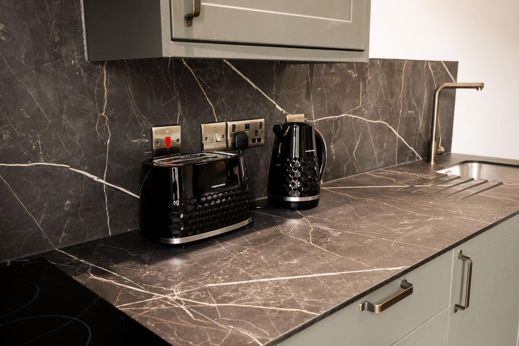 Sleek marble-effect kitchen countertop with ket...
