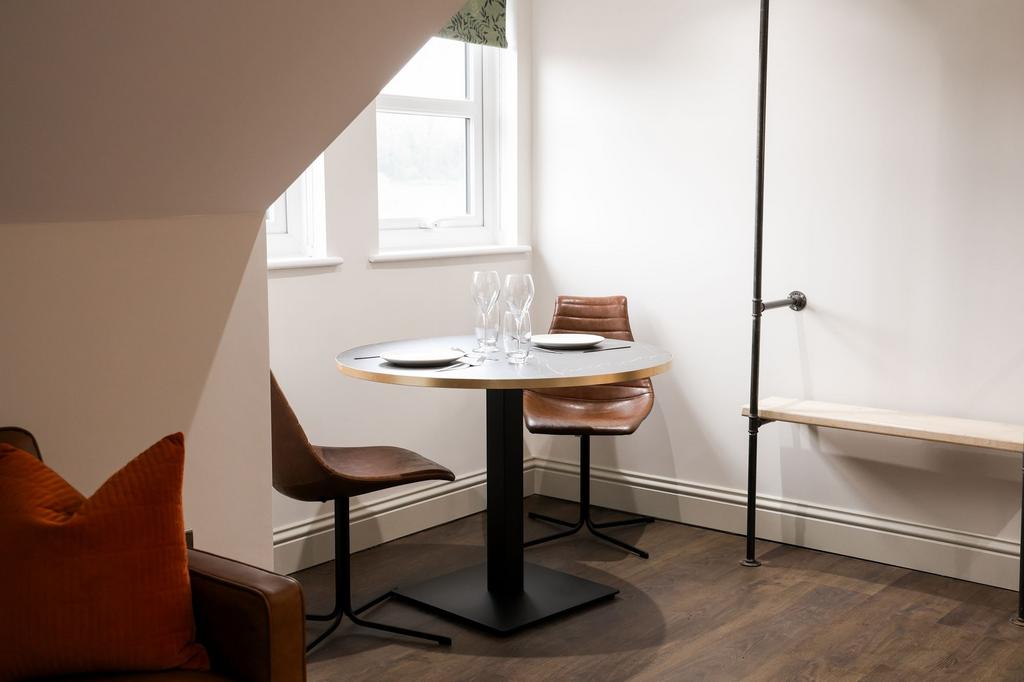 Bright dining nook with stylish leather chairs...