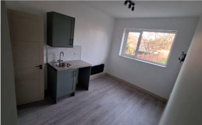 Compact kitchen with large window and neutral f...