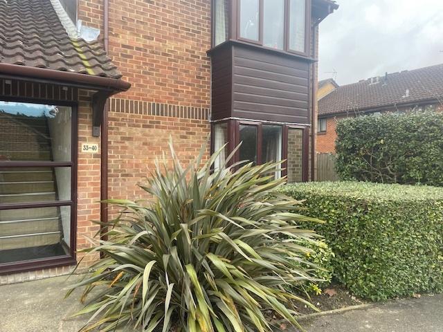 Well-maintained brick property with neat hedgin...