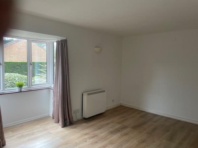 Bright, neutral living room with large bay wind...