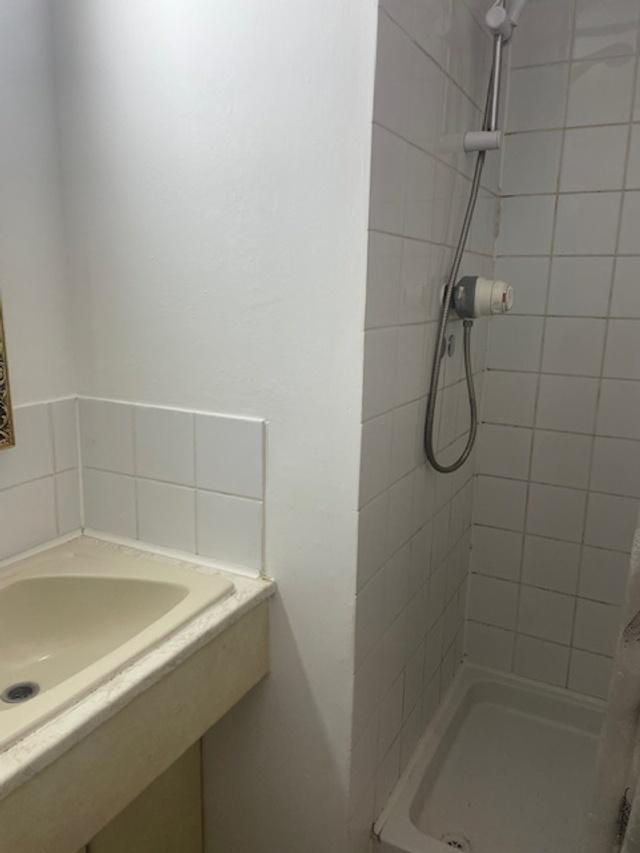Compact bathroom with a tiled walk-in shower an...