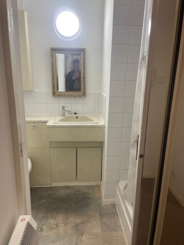 Compact bathroom with a vanity sink set in a fi...