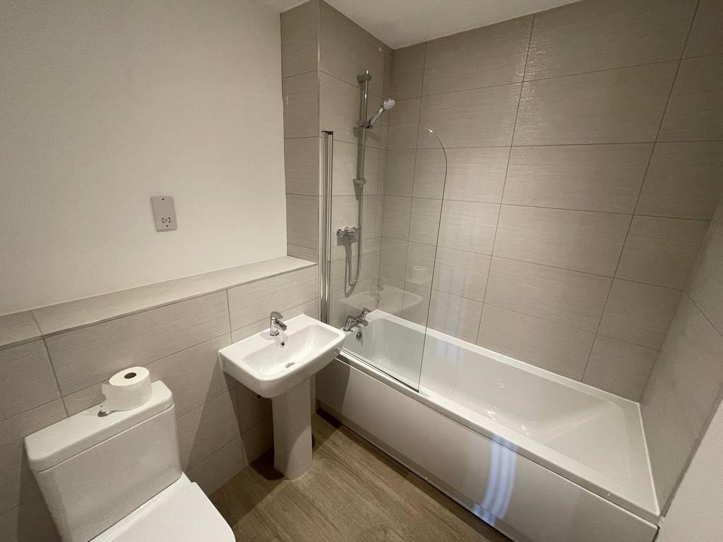 Bright, modern bathroom with a clean white bath...