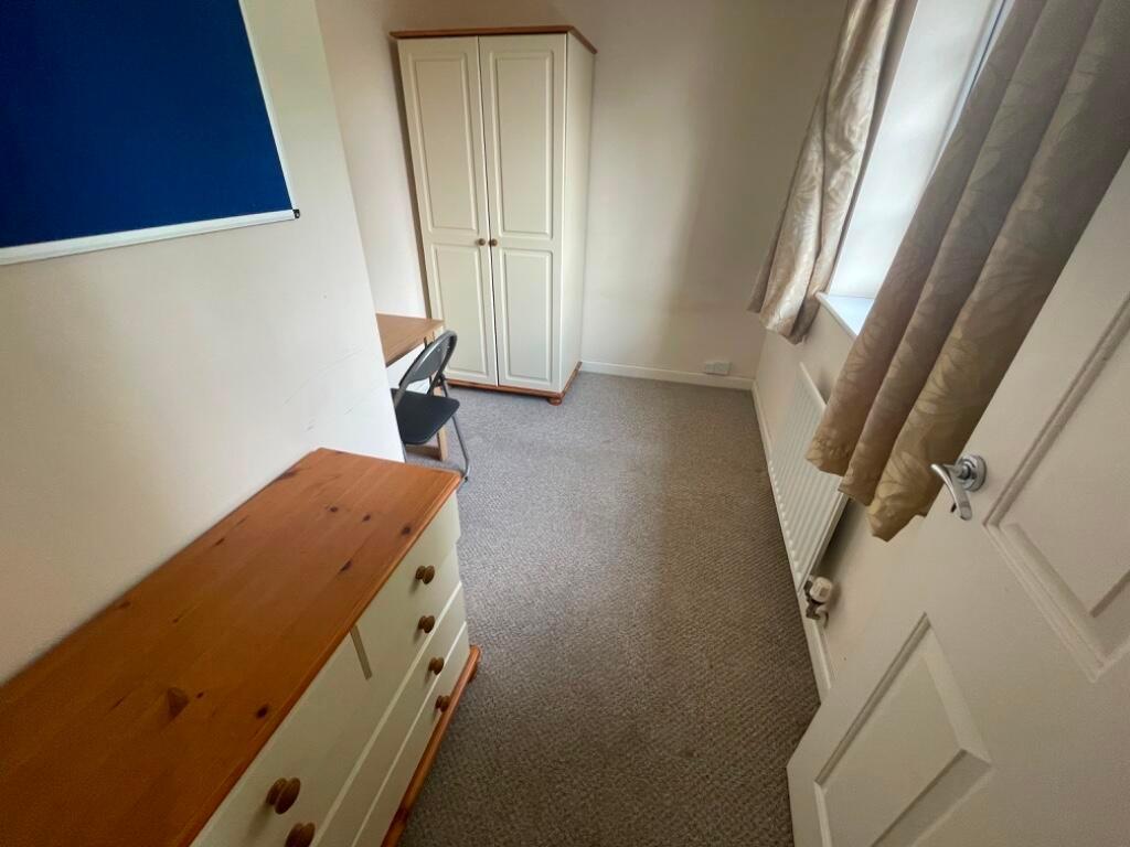 Neat single bedroom with built-in storage and a...