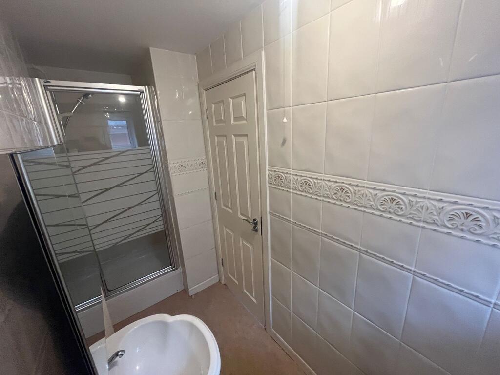 Tidy bathroom with a glass-enclosed shower, dec...