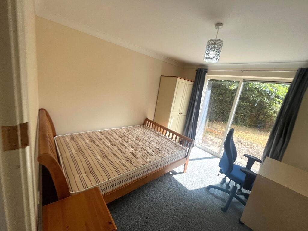 Bright double bedroom with large sliding glass ...