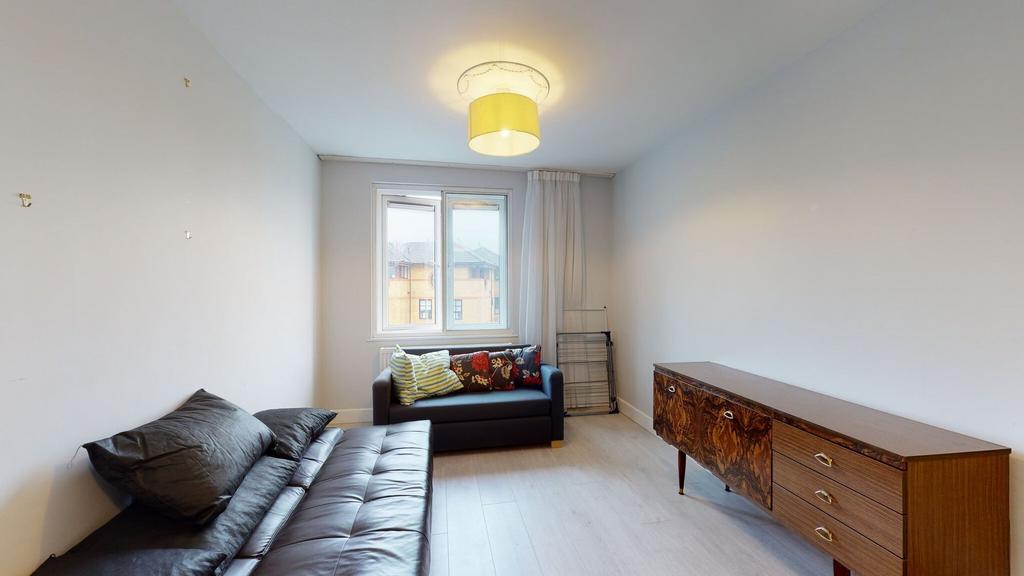 Bright, simply furnished living room with a win...