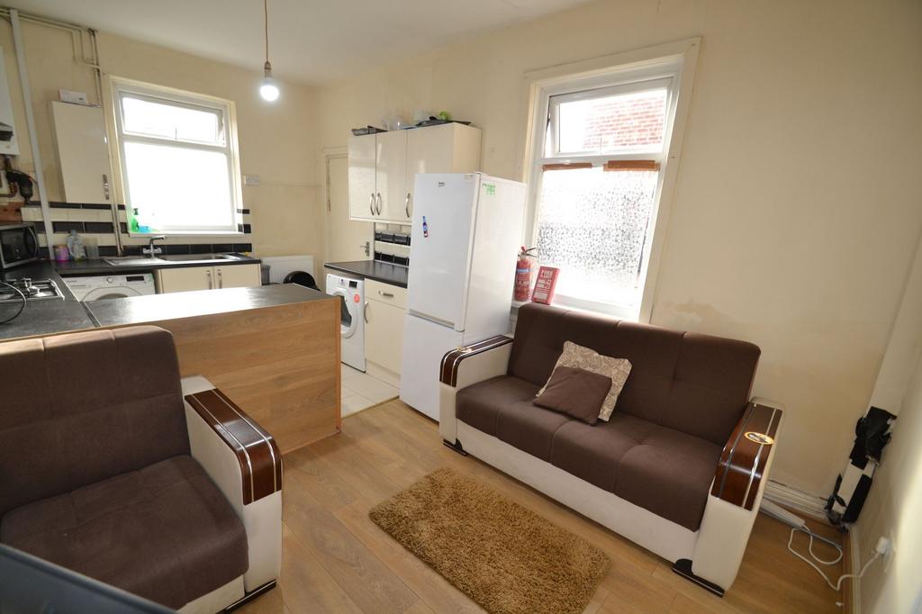 Compact open-plan living area with kitchenette,...