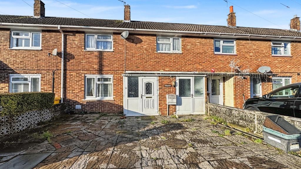 Brick terraced house with paved driveway and su...