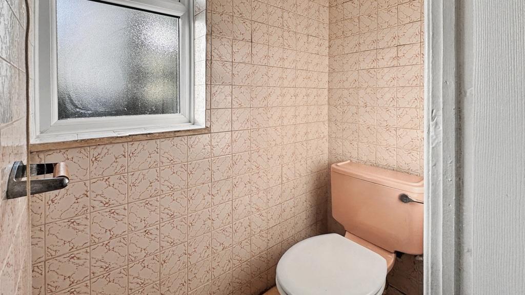 Compact bathroom with natural light and neutral...