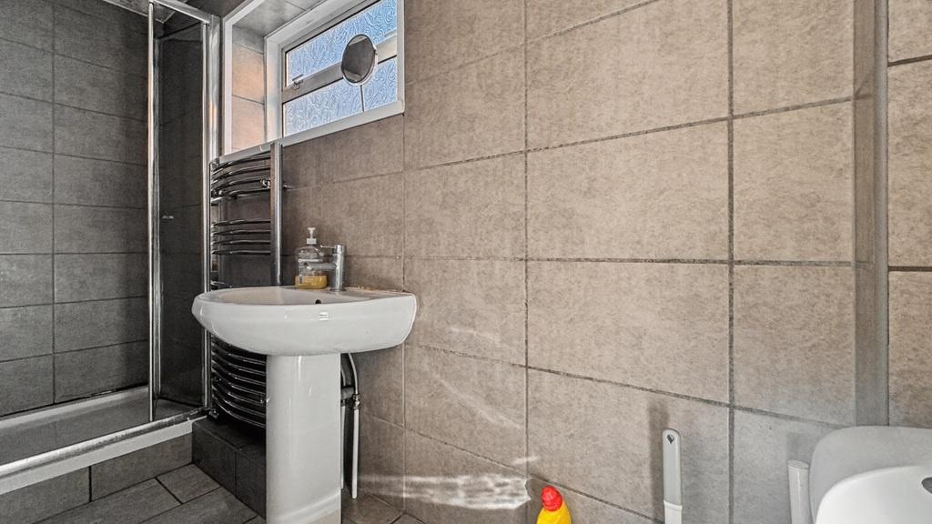 Modern tiled bathroom with shower and sink...