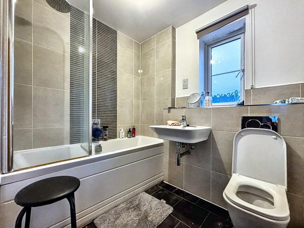 Modern bathroom with a combined bath and glass-...