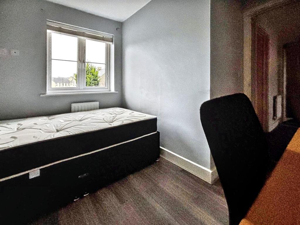 Compact, tidy bedroom with a raised double bed,...