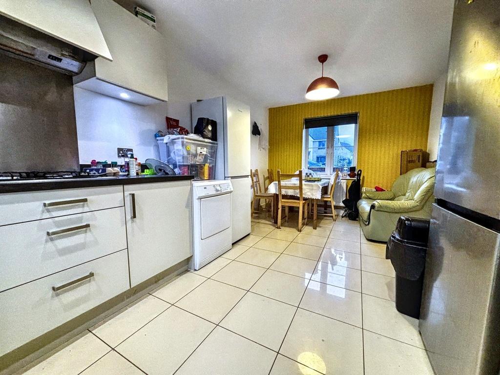Bright modern kitchen with white cabinets, tile...