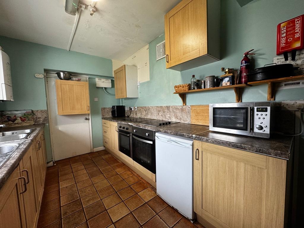 Long galley kitchen with wood-effect cabinets, ...